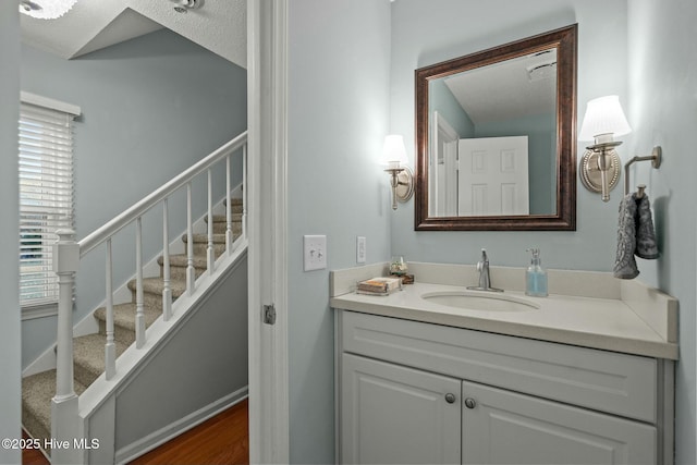 bathroom featuring vanity, wood-type flooring, and a textured ceiling