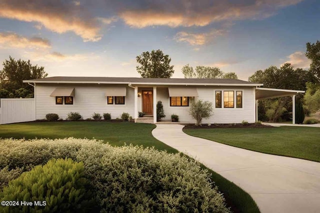 view of front of home featuring a yard and a carport