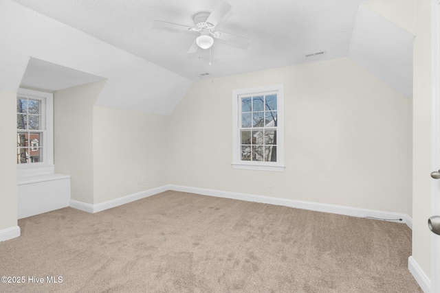 bonus room featuring ceiling fan, light carpet, and lofted ceiling