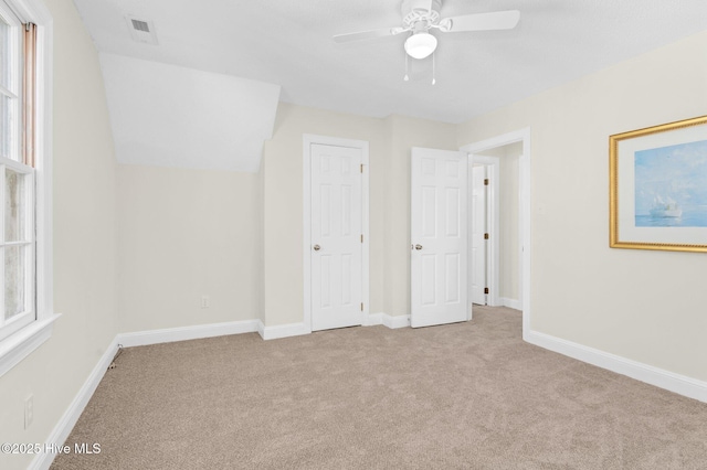 unfurnished bedroom featuring light colored carpet, ceiling fan, and lofted ceiling