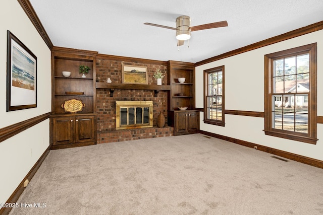 unfurnished living room featuring ceiling fan, a brick fireplace, crown molding, a textured ceiling, and light carpet