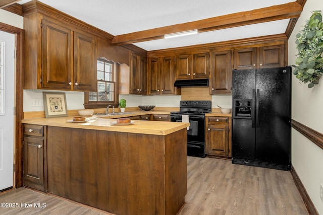 kitchen featuring black appliances, sink, light wood-type flooring, beamed ceiling, and kitchen peninsula