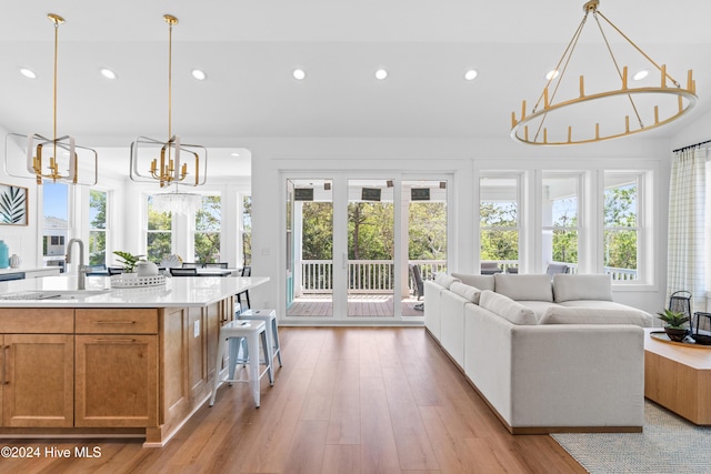 interior space with sink, light hardwood / wood-style floors, and an inviting chandelier