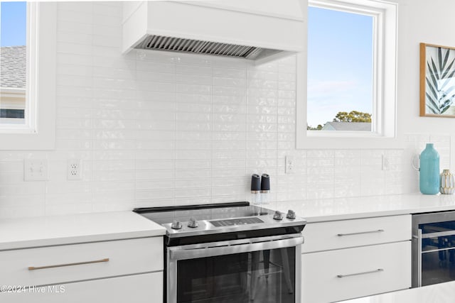 kitchen featuring white cabinets, custom range hood, decorative backsplash, and stainless steel electric range oven