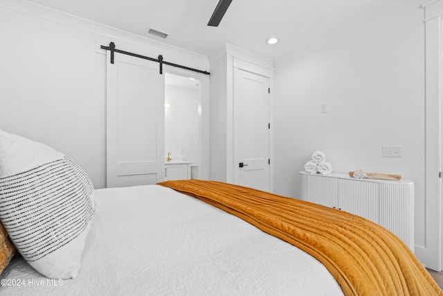 bedroom with a barn door, radiator, crown molding, and ceiling fan