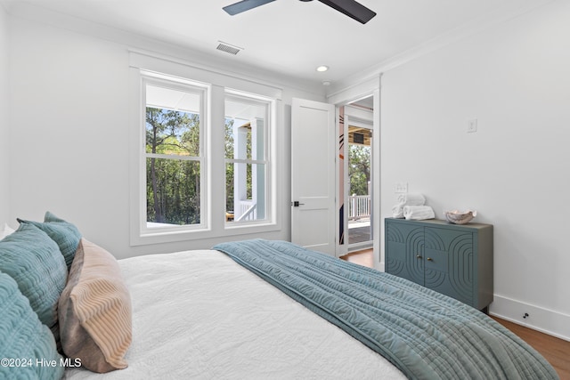 bedroom featuring multiple windows, ceiling fan, wood-type flooring, and access to exterior