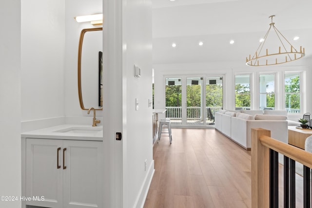 bathroom featuring hardwood / wood-style floors, plenty of natural light, sink, and a notable chandelier