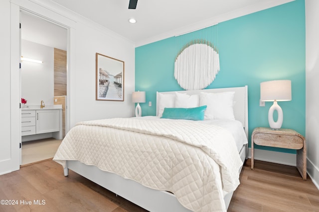 bedroom featuring ensuite bath, ceiling fan, crown molding, and wood-type flooring