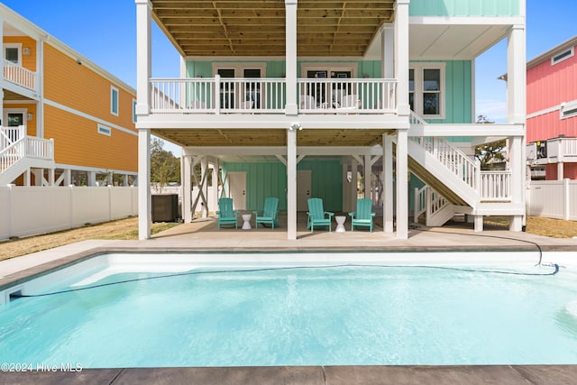 back of house featuring a pool side deck and a patio area