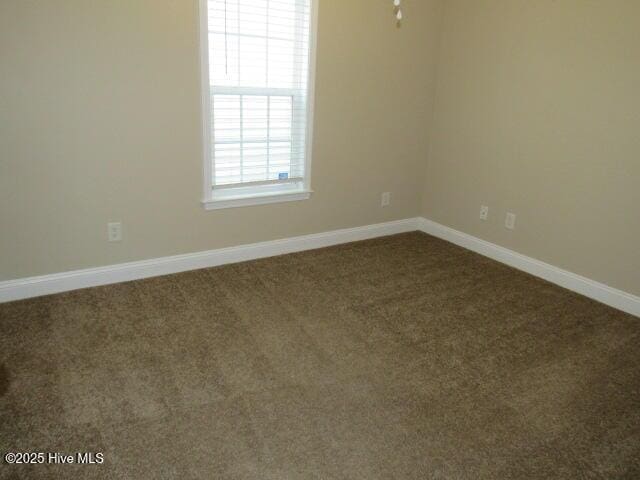 empty room featuring carpet floors and baseboards