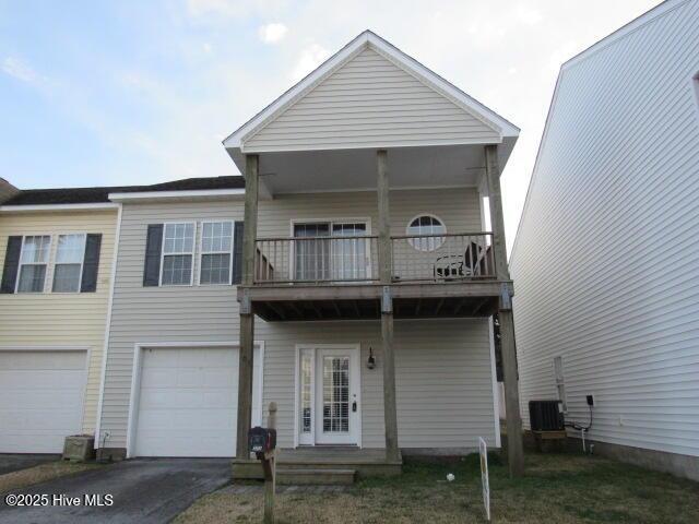 exterior space with a balcony, driveway, and an attached garage