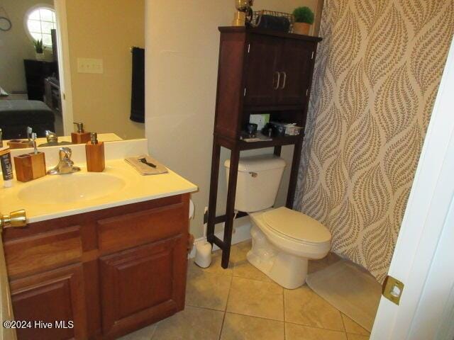 bathroom featuring tile patterned flooring, vanity, and toilet