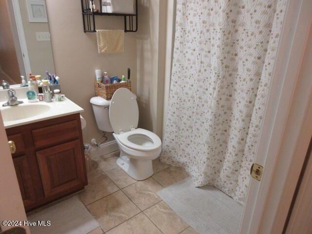 bathroom featuring tile patterned flooring, vanity, and toilet