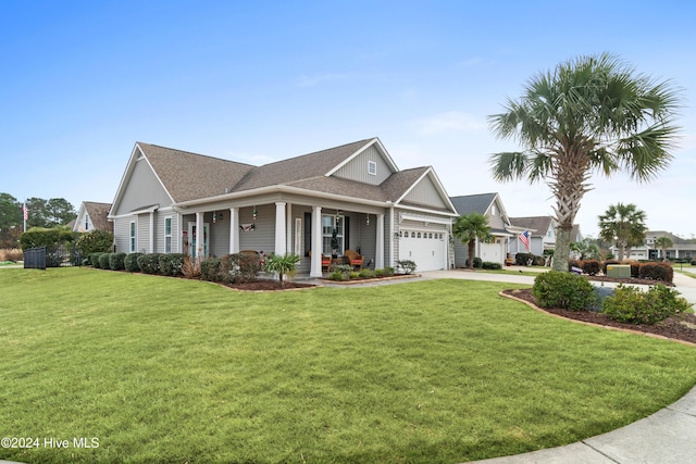 view of front of property with board and batten siding, covered porch, a front lawn, concrete driveway, and an attached garage