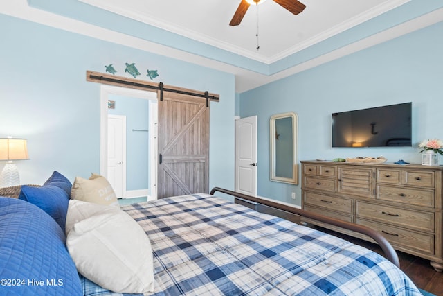 bedroom featuring dark hardwood / wood-style flooring, ornamental molding, a barn door, and ceiling fan