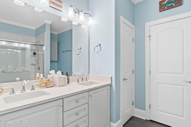 bathroom featuring a sink, ornamental molding, a stall shower, and double vanity