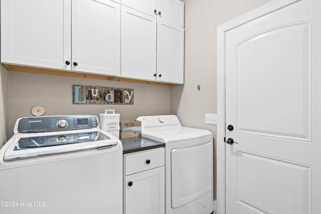 clothes washing area with washing machine and clothes dryer and cabinet space