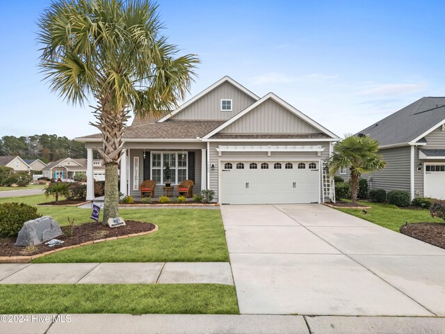 view of front of house featuring a garage, board and batten siding, a porch, a front yard, and concrete driveway