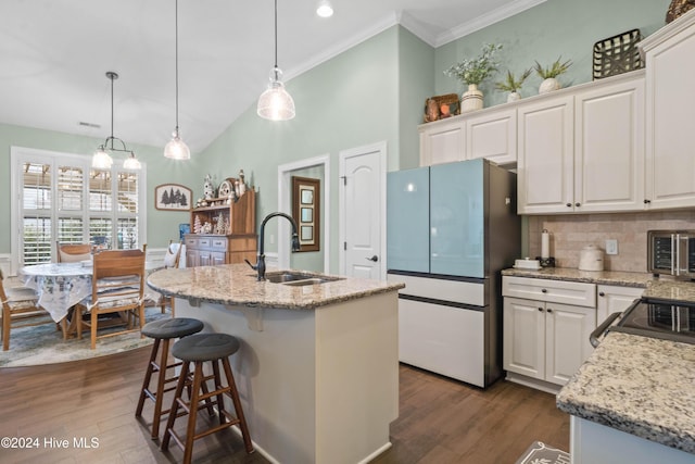 kitchen featuring a kitchen island with sink, hanging light fixtures, and white cabinetry