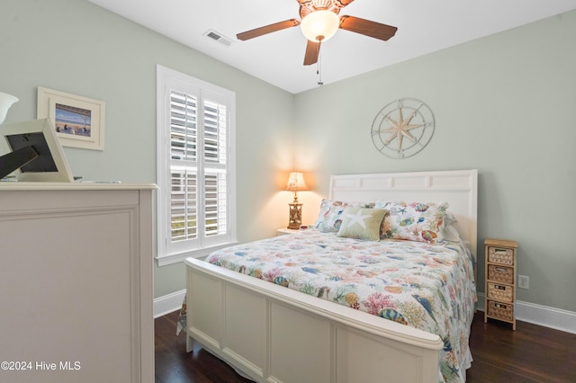 bedroom featuring visible vents, baseboards, dark wood-type flooring, and multiple windows