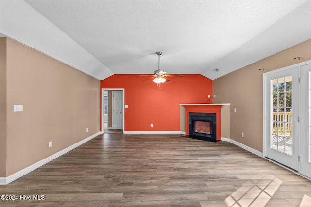 unfurnished living room with wood-type flooring, vaulted ceiling, and ceiling fan