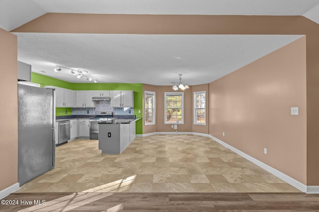 kitchen featuring a chandelier, white cabinets, stainless steel appliances, and vaulted ceiling