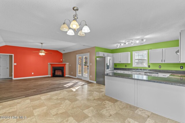 kitchen featuring white cabinetry, light hardwood / wood-style flooring, stainless steel appliances, and lofted ceiling