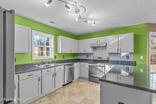 kitchen with sink, a textured ceiling, white cabinetry, kitchen peninsula, and stainless steel appliances