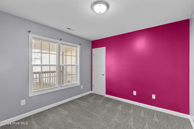 carpeted spare room with a textured ceiling