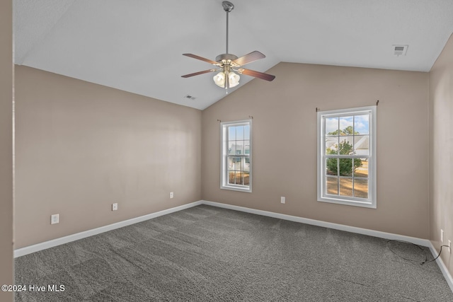 carpeted spare room with ceiling fan, a healthy amount of sunlight, and lofted ceiling