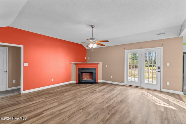 unfurnished living room featuring a textured ceiling, light hardwood / wood-style floors, vaulted ceiling, and ceiling fan