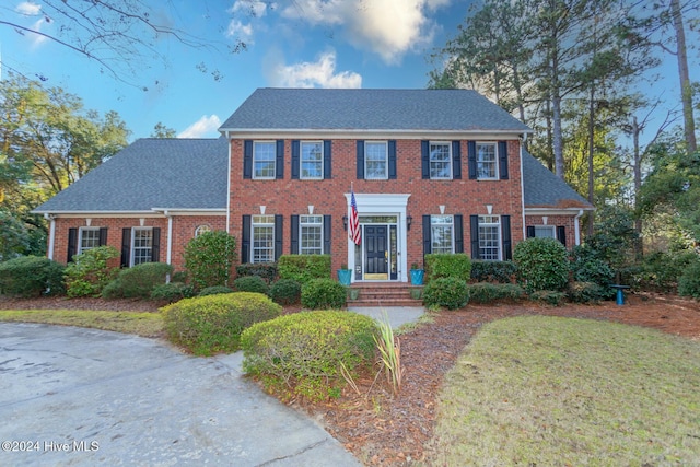 colonial house featuring a front lawn