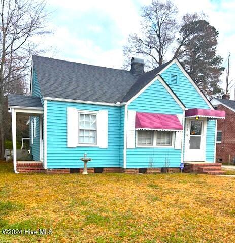 rear view of property featuring a yard