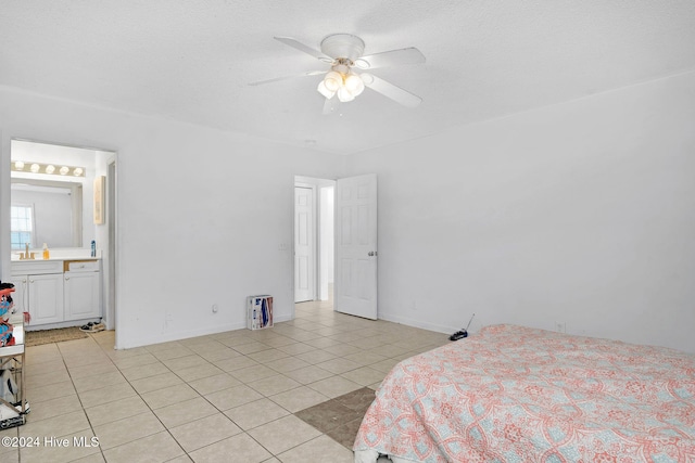 bedroom featuring connected bathroom, ceiling fan, sink, and light tile patterned flooring