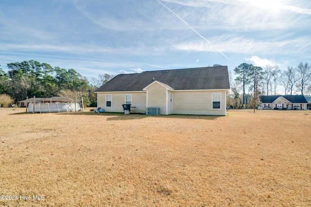 back of house with cooling unit and a swimming pool