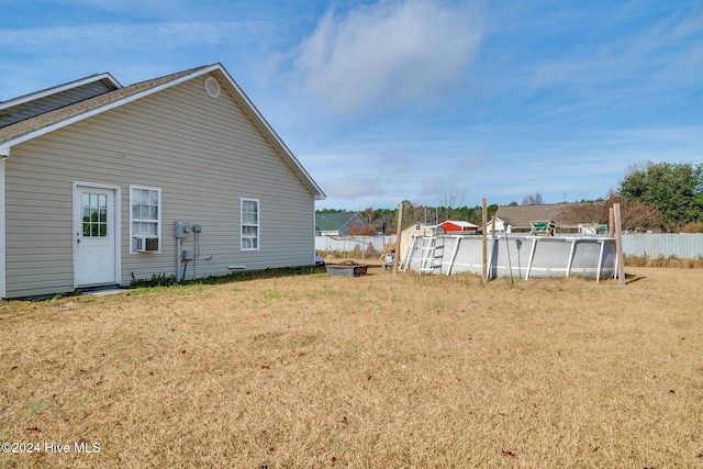 view of home's exterior with a fenced in pool, a yard, and cooling unit