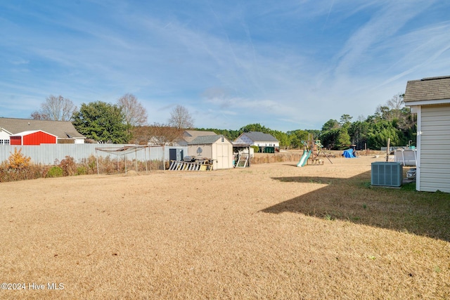 view of yard with a playground, cooling unit, and a shed