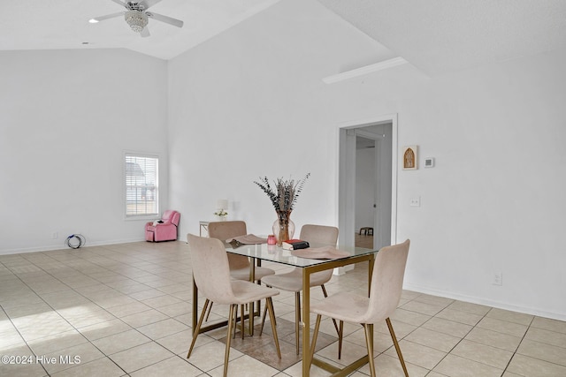 tiled dining area featuring ceiling fan and high vaulted ceiling