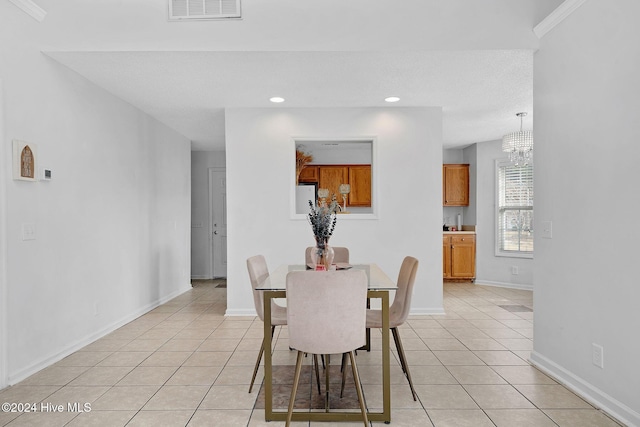 dining space featuring light tile patterned flooring, a chandelier, and ornamental molding