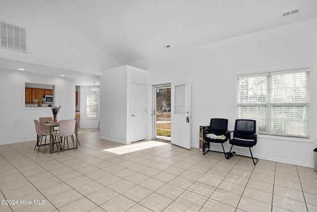 interior space with light tile patterned floors, high vaulted ceiling, and a healthy amount of sunlight