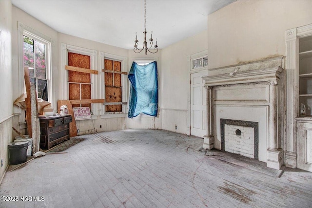 unfurnished living room featuring a chandelier