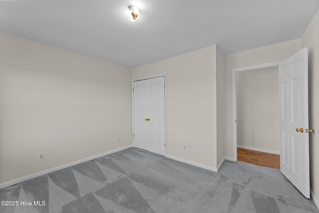 unfurnished bedroom with light carpet and a closet