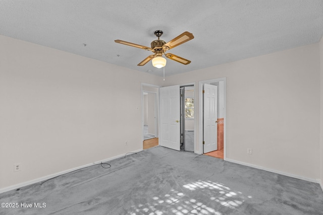 carpeted spare room featuring a textured ceiling and ceiling fan