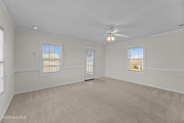 carpeted empty room featuring a textured ceiling, ceiling fan, and crown molding