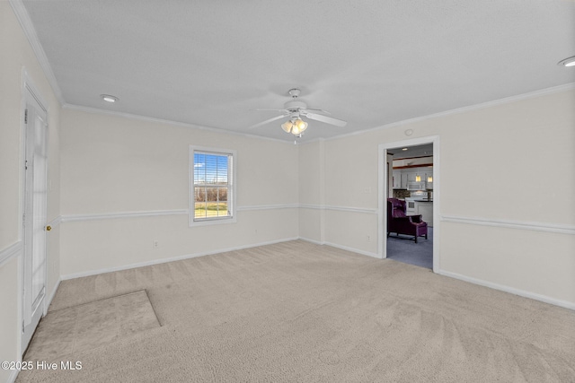 carpeted spare room with crown molding and ceiling fan