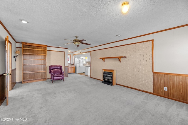 unfurnished room with a textured ceiling, carpet floors, and ceiling fan