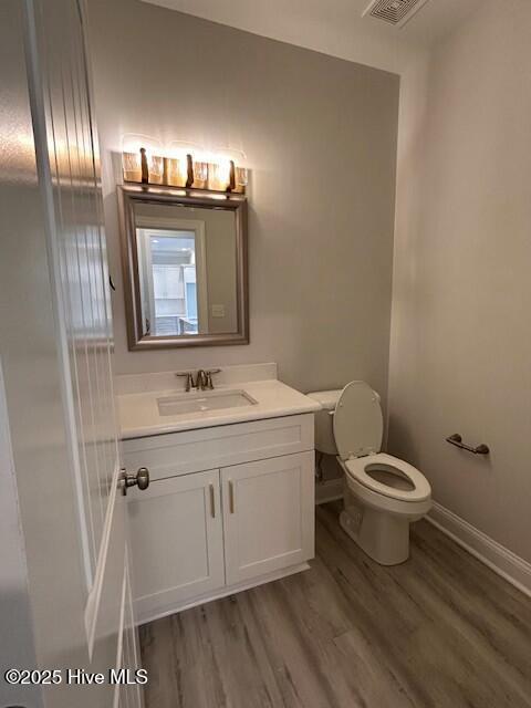 bathroom with vanity, wood-type flooring, and toilet