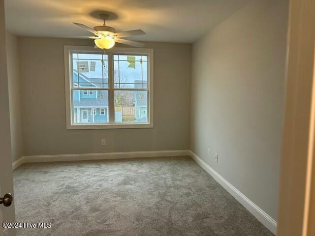 carpeted spare room featuring ceiling fan