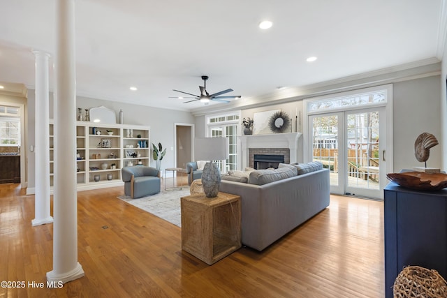 living room with a healthy amount of sunlight, ornate columns, and wood-type flooring