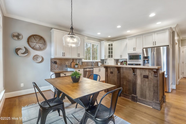 kitchen with pendant lighting, white cabinetry, and appliances with stainless steel finishes